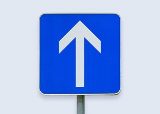 white arrow on blue road sign pointing up