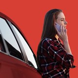 woman stands next to red car - with red background