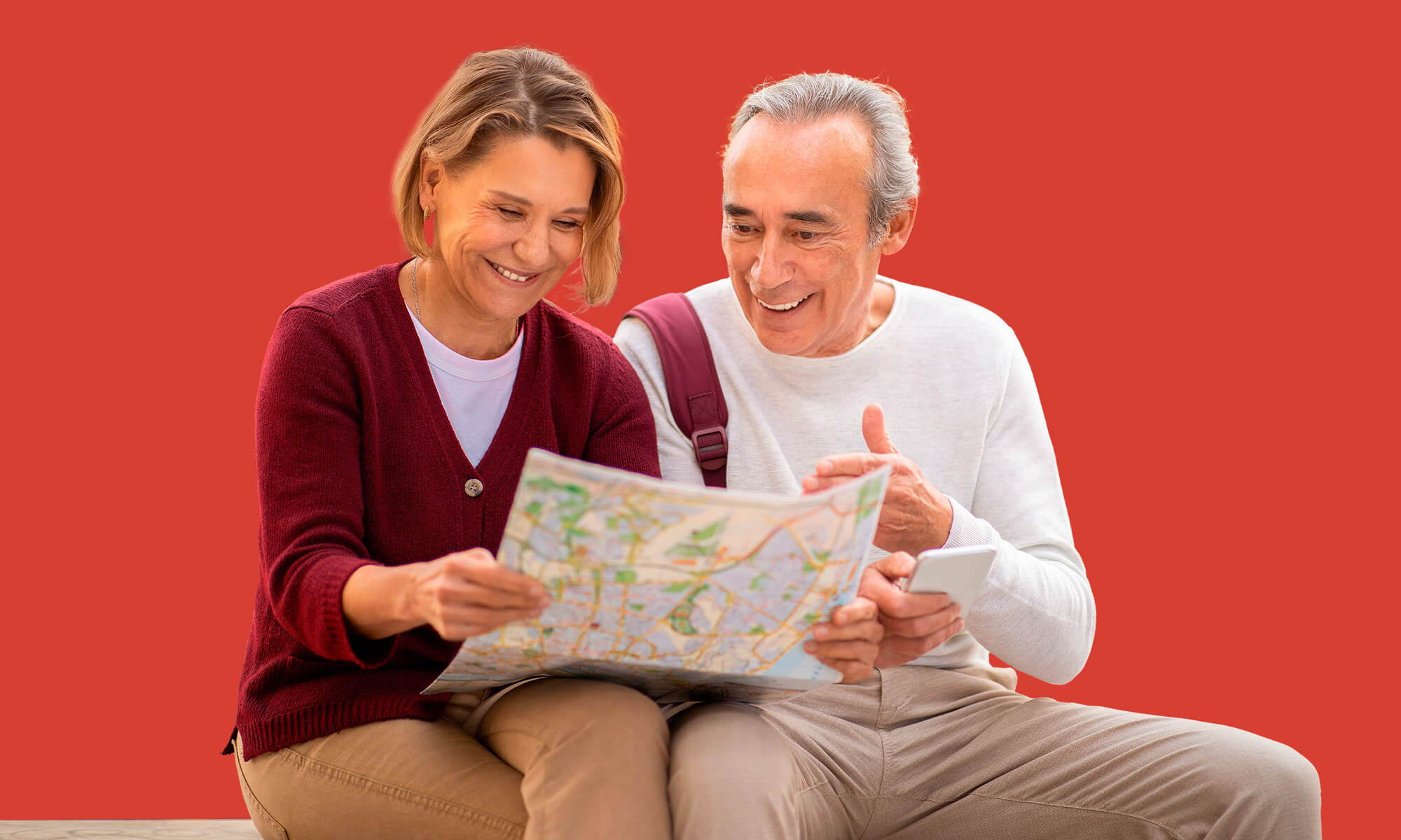 Couple sitting with map on red background
